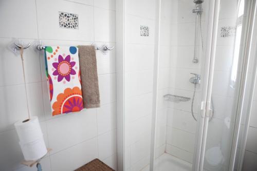 een badkamer met een douche en een schilderij aan de muur bij Aquarian Beachfront Apartment in Larnaka