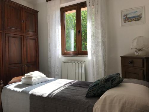Schlafzimmer mit einem Bett und einem Fenster in der Unterkunft La casa di nonna Bruna in Muggia
