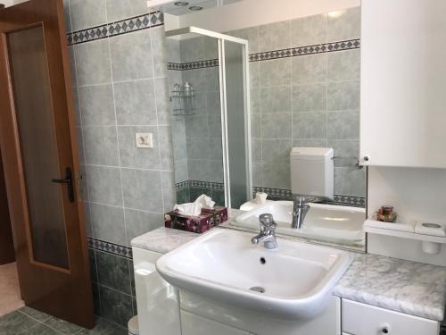 a bathroom with a sink and a shower at La casa di nonna Bruna in Muggia