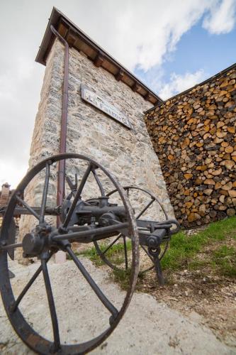 a stone building with a wheel next to it at La Fattoria dei Sibillini in Montemonaco