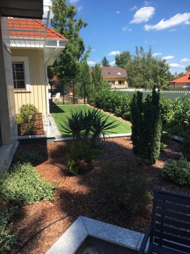 a yard with a bench in front of a house at Fedasz Dental Szálláshely in Pilisvörösvár