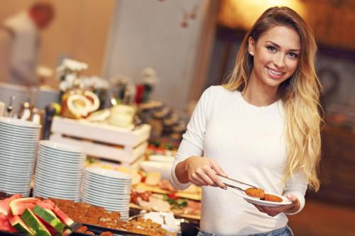 a woman holding a plate of food at Hotel Wisła Premium in Wisła