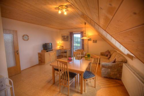 een woonkamer met een tafel en een bank bij Ferienwohnungen Lindleshof in Leinach