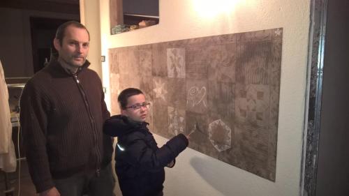 two men standing in front of a painting on a wall at Alpuntogiusto in Peveragno