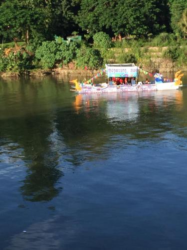 a boat on a river with a building on it at Merry Riverside Hotel in Luang Prabang