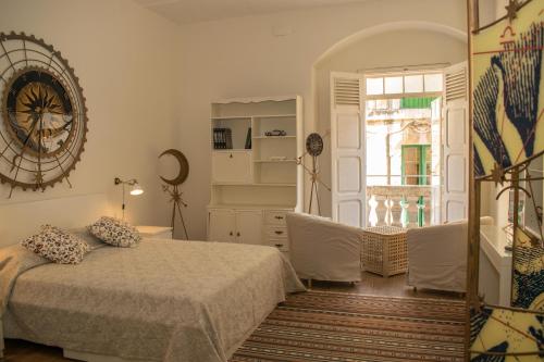 a bedroom with a bed and a large clock on the wall at Vincenti Strait Street Suite in Valletta