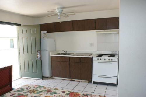 a kitchen with a white stove and a refrigerator at HWY Express Inn and Suites in Thatcher