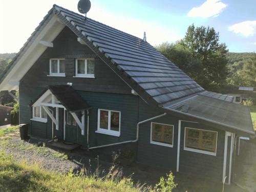una casa verde con techo de gambrel en Ferienhaus Momo, en Nieder-Kinzig