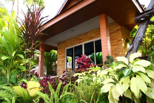 a garden in front of a house with plants at Tonnum Resort in Ban Khlong Khlaeng