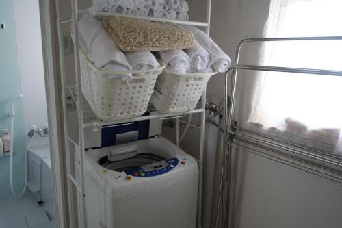 a laundry room with a washing machine and baskets at HDO Sumikawa Villa in Sapporo