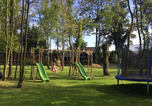 two children playing on a playground in a park at Hollands Oostenrijks huisje in Wieringerwerf