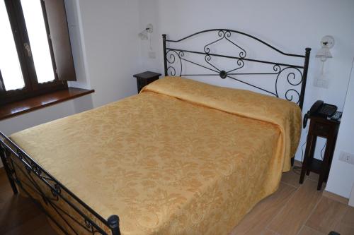 a bedroom with a bed with a yellow blanket at Agriturismo Antico Muro in Sassoferrato