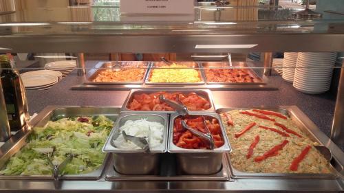 a buffet line with trays of different types of food at Balneario de Ledesma in Vega de Tirados