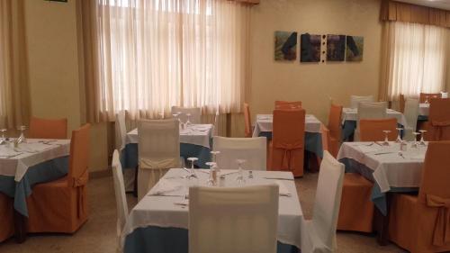 a dining room with tables and chairs with white tablecloths at Balneario de Ledesma in Vega de Tirados