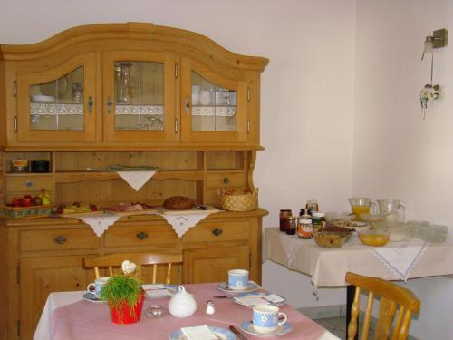 a kitchen with a table and a wooden cabinet at Haus am Brunnen in Umhausen