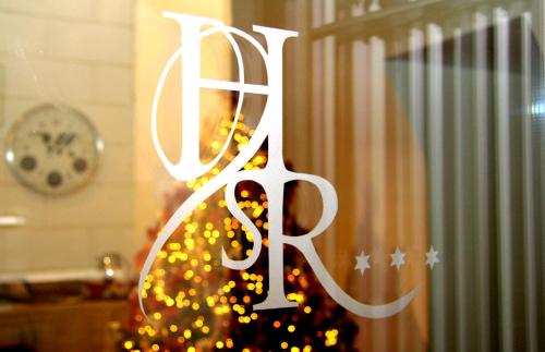 a christmas tree with a letter h in a window at San Rocco Hotel in Scanzorosciate