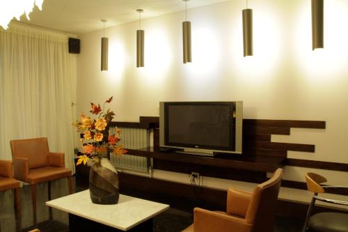 a living room with a tv and a table and chairs at Hotel Crillon Mendoza in Mendoza