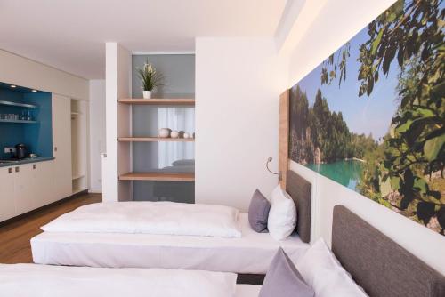 een slaapkamer met 2 bedden en een schilderij aan de muur bij Boardinghouse am Teuto in Lengerich