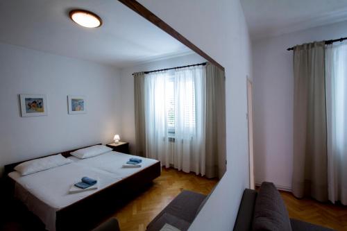 a bedroom with a bed and a couch and a window at Sobe Tonica in Krk