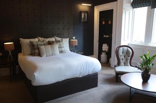 a bedroom with a bed and a table and a chair at The Belhaven Hotel in Glasgow