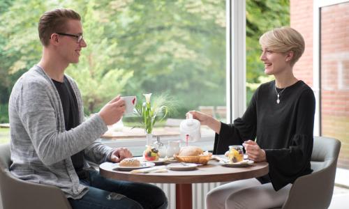 a man and woman sitting at a table eating food at Hotel Christophorus in Berlin