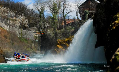 a group of people on a raft in front of a waterfall at Apartment Kolaković in Slunj