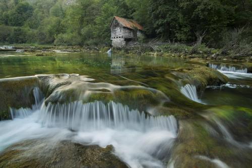 an old house in the middle of a river at Apartment Kolaković in Slunj