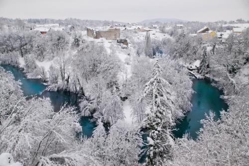 an aerial view of a river with snow covered trees at Apartment Kolaković in Slunj