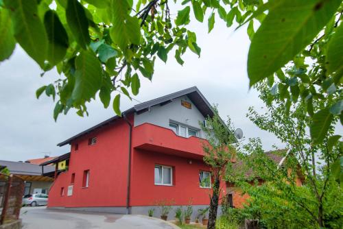 a red and white building with a black roof at Apartment Kolaković in Slunj