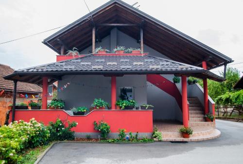 a red house with a black roof at Apartment Kolaković in Slunj