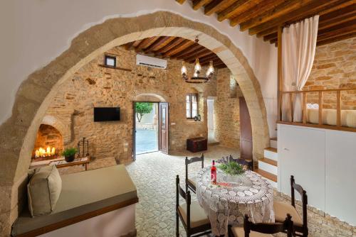 a dining room with a table and a stone wall at Rodia House in Lardos