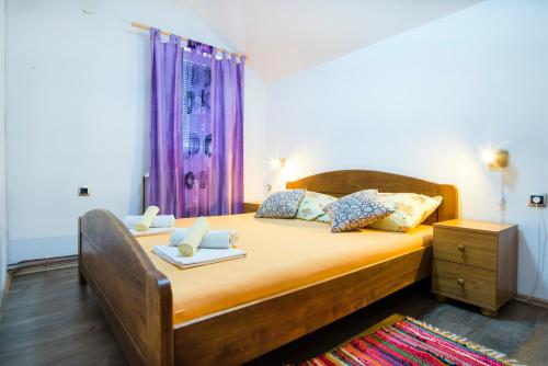 a bedroom with a bed with yellow sheets and pillows at Apartment Kolaković in Slunj