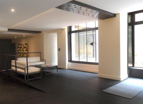 a living room with chairs and a large window at Studio luxe hyper centre piscine in Bordeaux
