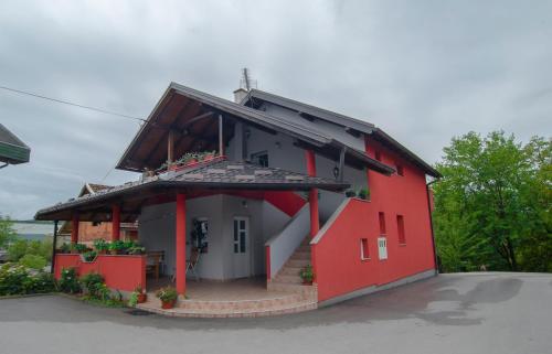 a red house with a black roof at Apartment Kolaković in Slunj