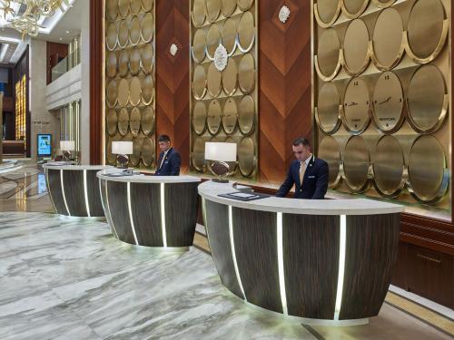 two men in suits sitting at tables in a lobby at Elite World Europe Hotel in Istanbul