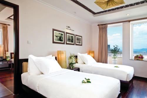 Giường trong phòng chung tại Cherish Hue Hotel