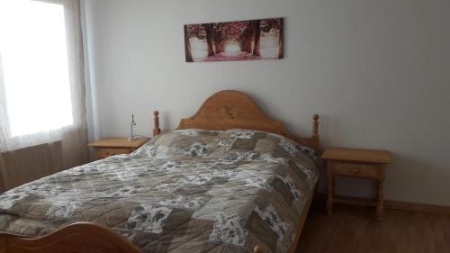 a bed in a bedroom with two night stands and a window at Ferienwohnung am Theo Carlen Platz in Ormesheim