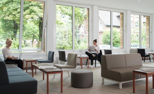 two women sitting in a waiting room with their laptops at Hotel Christophorus in Berlin