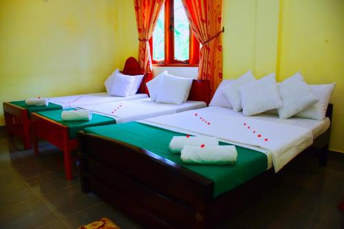 two twin beds in a room with a window at Mount View in Polonnaruwa