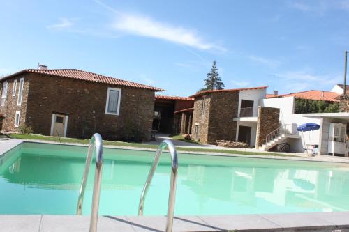 a swimming pool in a house with two buildings at Agroturismo Casal de Castro in Mirandela