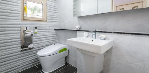 a bathroom with a white toilet and a sink at Happiness Pension in Jeju