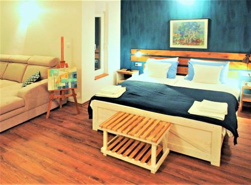 a bedroom with a large bed and a couch at MaraMare Apartments in Stara Baška
