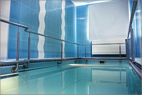 a swimming pool with blue tiled walls and water at Near the Lake in Lviv