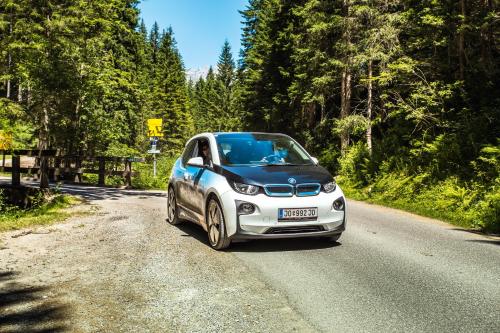 a small car is driving down a road at Landhotel Alpenhof Filzmoos in Filzmoos