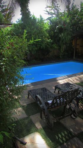 a black bench sitting next to a swimming pool at Victoria Manor in Upington