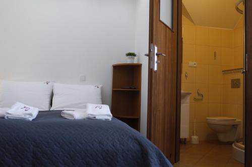 a bedroom with a bed and a bathroom with a toilet at Malinowe Lato in Grzybowo