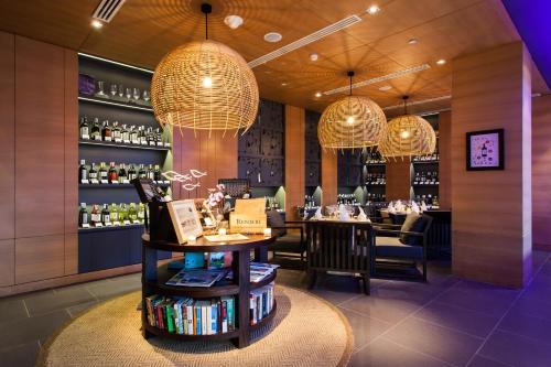 a restaurant with a table and chairs and chandeliers at Amari Hua Hin in Hua Hin