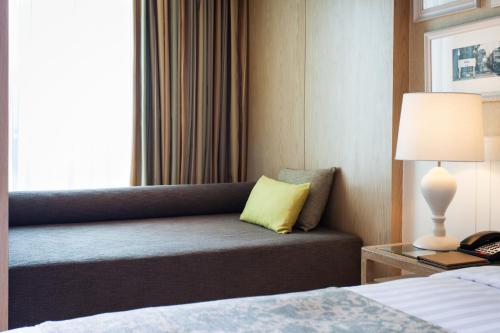a hotel room with a couch with a yellow pillow at Amari Hua Hin in Hua Hin