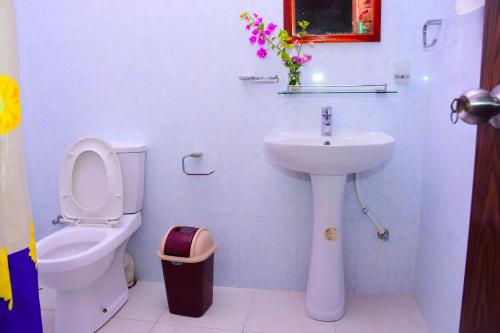 a white bathroom with a toilet and a sink at Mount View in Polonnaruwa