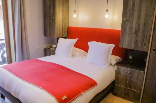a bedroom with a large bed with a red headboard at Bellevue in Les Gets